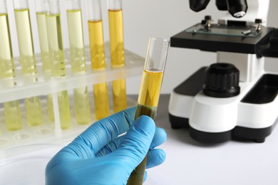 Photo of Nurse holding tube with urine sample for analysis in laboratory, closeup