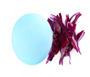 Photo of Light blue Easter egg painted with natural dye and red shredded cabbage on white background, top view