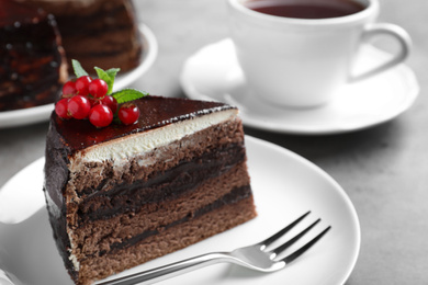 Tasty chocolate cake with berries on grey table, closeup