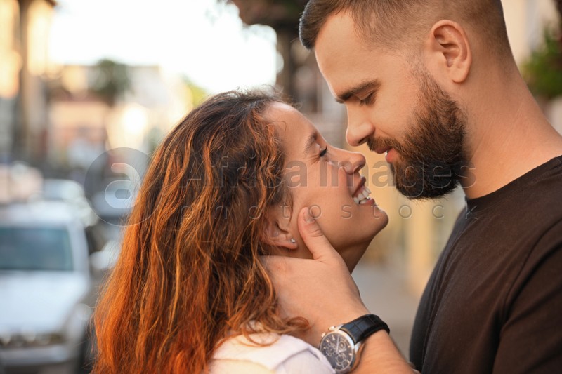 Happy young couple kissing on city street