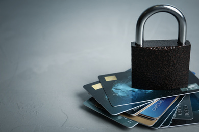 Credit cards and padlock on light grey background, space for text. Protection from cyber attack
