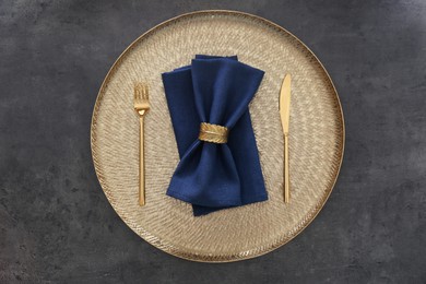 Tray with blue napkins, decorative ring and cutlery on grey table, top view