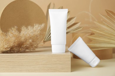 Photo of Composition with tubes of hand cream on beige background