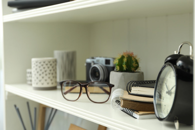 White shelving unit with glasses and different decorative elements