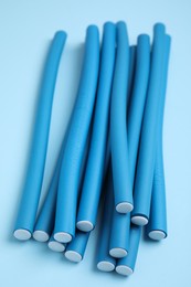 Curling rods on turquoise background. Hair styling tool