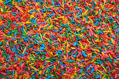 Bright colorful sprinkles as background, top view. Confectionery decor