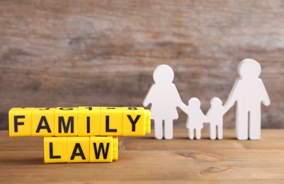 Cubes with letters and family figure on wooden table. Family law concept