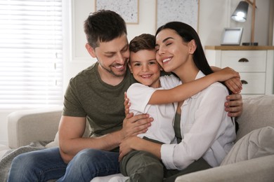 Happy family on sofa at home. Adoption concept