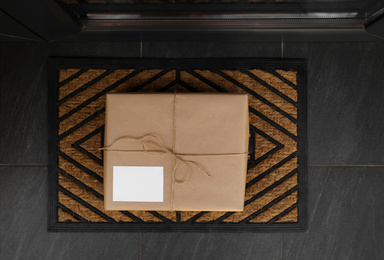 Delivered parcel on door mat near entrance, top view