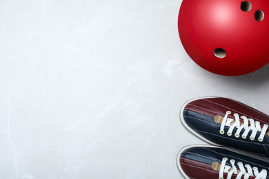 Bowling ball and shoes on light grey marble background, flat lay. Space for text