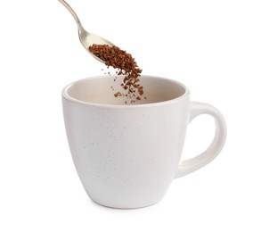 Pouring aromatic instant coffee into cup on white background