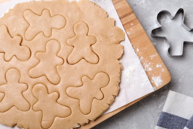 Making homemade Christmas cookies on light grey marble table, flat lay. Gingerbread men