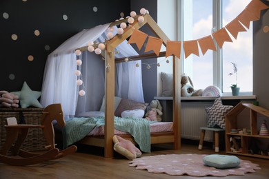 Stylish child room interior with house bed and different toys