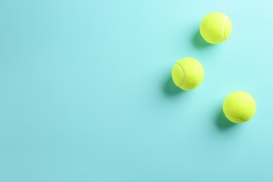 Tennis balls on light blue background, flat lay. Space for text