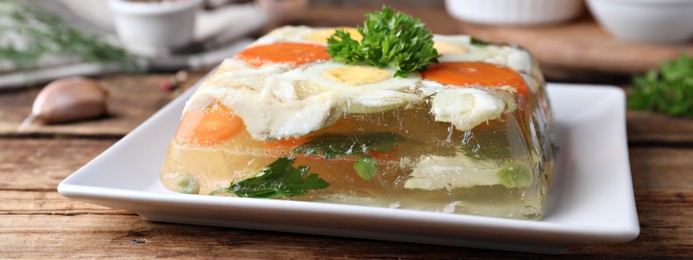 Delicious fish aspic served on wooden table, closeup. Banner design