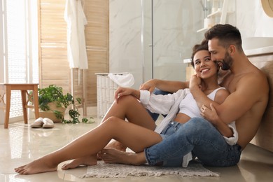 Lovely couple enjoying time together on floor in bathroom
