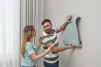 Young couple with new wall paper and color palette  indoors