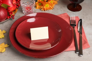 Beautiful autumn place setting with blank card and decor on grey table