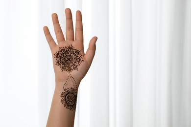 Little girl with henna tattoo on palm, closeup and space for text. Traditional mehndi ornament