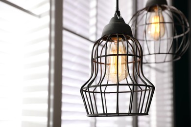 Photo of Stylish metallic pendant lamp with Edison light bulb indoors