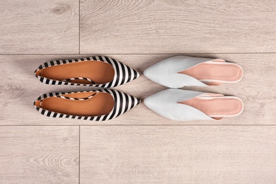 Photo of Different female shoes on wooden background, top view