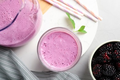 Delicious blackberry smoothie and berries on white table, flat lay