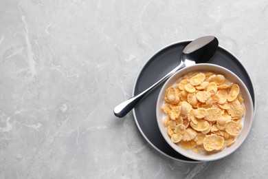 Tasty cornflakes with milk served on light grey table, top view. Space for text