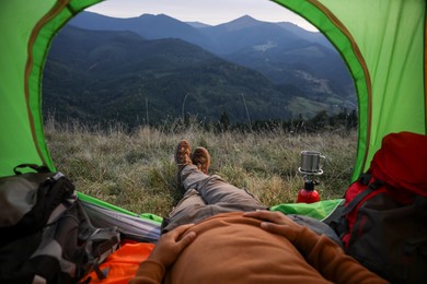 Man resting inside of camping tent in mountains, closeup