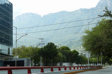Modern road with cars in city near mountains