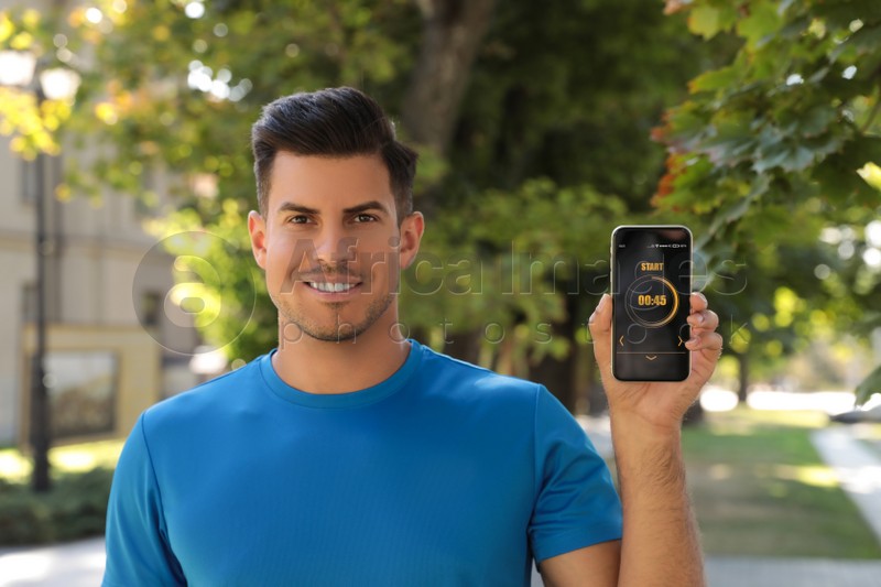 Photo of Man showing smartphone with fitness app on city street