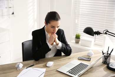 Stressed and tired young woman at workplace