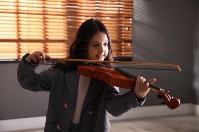 Preteen girl playing violin in studio at music lesson