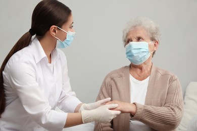 Doctor taking care of senior woman with protective mask at nursing home