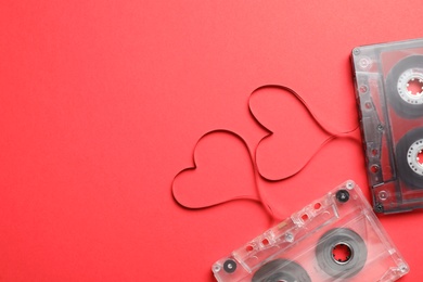 Music cassettes and hearts made of tape on red background, flat lay with space for text. Listening love songs