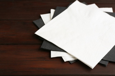 Clean napkins on wooden table, closeup. Personal hygiene