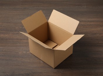 Empty open cardboard box on wooden table