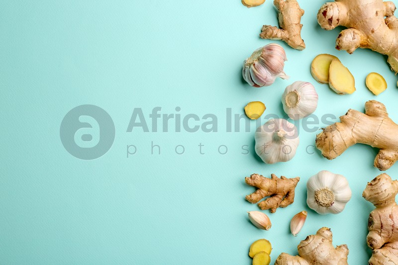 Photo of Ginger and garlic on turquoise table, flat lay with space for text. Natural cold remedies