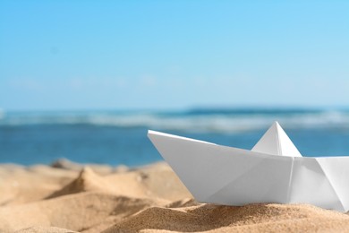White paper boat near sea on sunny day, closeup. Space for text