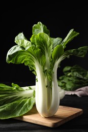 Fresh green pak choy cabbages on black wooden table
