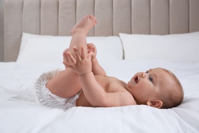 Cute baby in dry soft diaper on white bed
