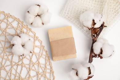 Soap bar and cotton flowers on white background, flat lay. Eco friendly personal care product