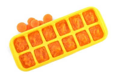 Carrot puree in ice cube tray on white background, top view. Ready for freezing