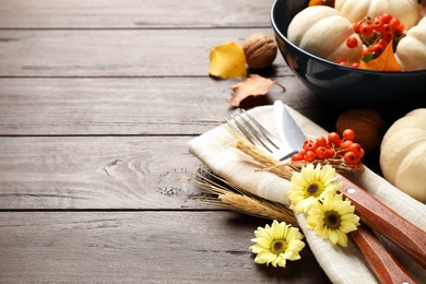 Festive table setting with autumn decor and space for text on wooden background, closeup. Thanksgiving Day celebration