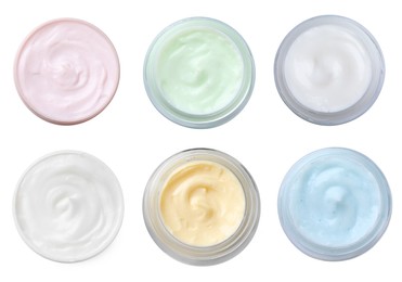 Set with jars of body cream on white background, top view