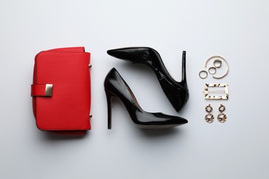 Stylish woman's bag, shoes and bijouterie on light background, flat lay