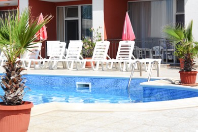 Photo of Outdoor swimming pool and loungers at resort sunny day