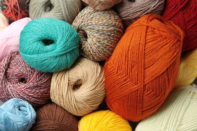 Photo of Different balls of woolen knitting yarns as background, top view