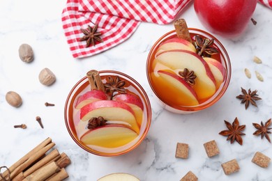 Aromatic hot mulled cider on white marble table, flat lay