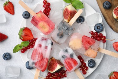 Photo of Flat lay composition with fruit and berry ice pops on white table