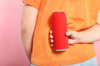 Photo of Woman holding red beverage can on pink background, closeup